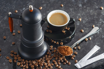 Coffee maker Type geyser and black colored coffee cup, with coffee beans and freshly ground coffee in a spoon