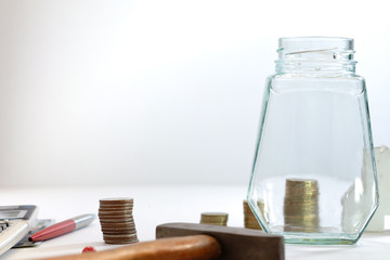 Coin stacked, glass jars, pens and calculators placed on a white background, images for financial business concepts with copy space