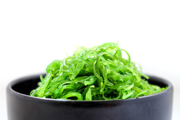 Hiyashi Wakame Chuka or seaweed salad in black bowl on white background ,Japanese food