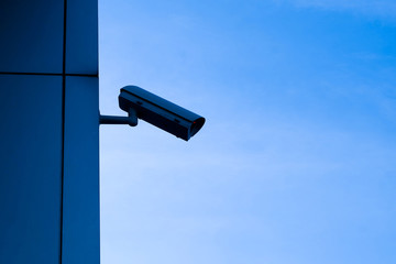CCTV is attached to the wall next to the outdoor home on night sky background with copy space