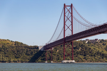 Calm river and a red suspension bridge