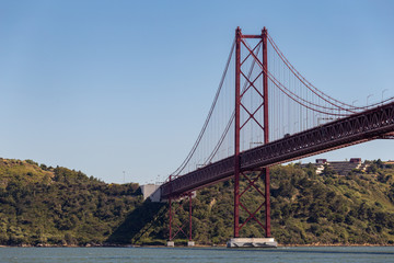Calm river and a red suspension bridge
