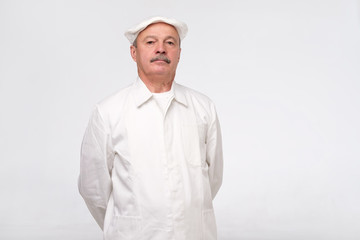 Mature hispanic chef looking confident isolated over white background. Experienced man is happy to cook for you.