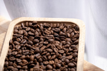 coffee beans and wooden plate on the table near the window
