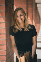 Portrait of a blonde woman in red brick hallway