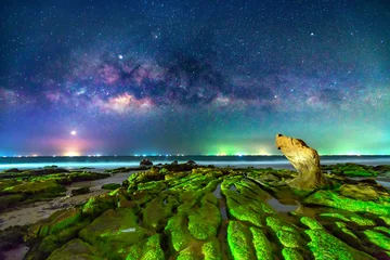 Photo sur Plexiglas Blue nuit Night landscape with milky way and mossy rocks on the beach
