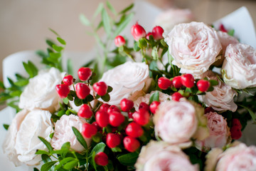 beautiful bouquet of flowers from delicate tea bush roses and decorative red berries