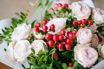 beautiful bouquet of flowers from delicate tea bush roses and decorative red berries