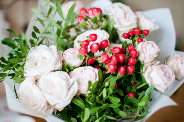 beautiful bouquet of flowers from delicate tea bush roses and decorative red berries