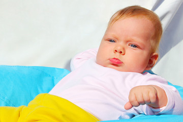 Cute baby girl wearing white shirt and yellow panties lying and looking somewhere. Family, childhood, people concept. 