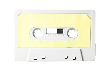 Fototapeta premium Close-up front shot: an old vintage cassette tape (obsolete music technology). Pale yellow label over a white plastic body.