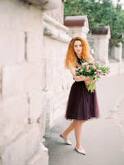 Naklejka premium young beauty woman with flower buquet on the spring street. film analog photography