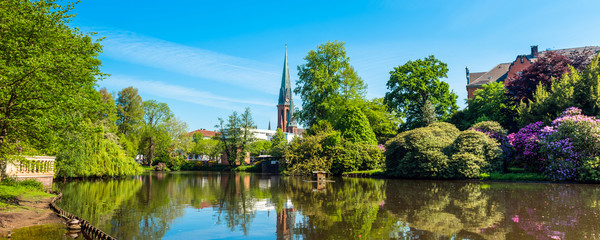 View of the pond and St. Lamberti Church of Oldenburg, Germany. - obrazy, fototapety, plakaty