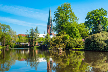 Fototapeta na wymiar View of the pond and St. Lamberti Church of Oldenburg, Germany.