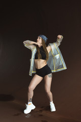 Urban hip hop style dancer practicing dance moves in industrial zone.