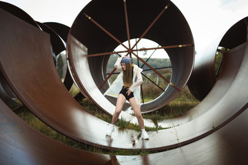 Urban hip hop style dancer practicing dance moves in industrial zone.