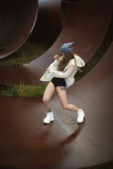 Urban hip hop style dancer practicing dance moves in industrial zone.