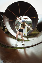 Urban hip hop style dancer practicing dance moves in industrial zone.