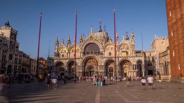 Basilica of St Mark timelapse hyperlapse and San Marco campanile. It is cathedral church of Roman Catholic Archdiocese of Venice. It lies at Piazza San Marco. Tourists walking in front of it. Venice