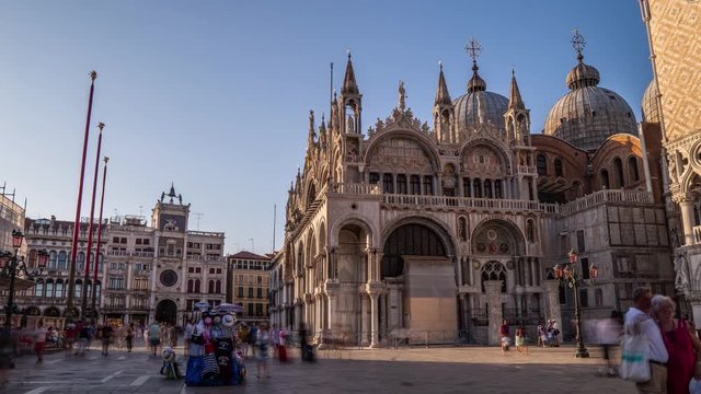 Basilica of St Mark timelapse hyperlapse and San Marco campanile. It is cathedral church of Roman Catholic Archdiocese of Venice. It lies at Piazza San Marco. Tourists walking in front of it. Venice