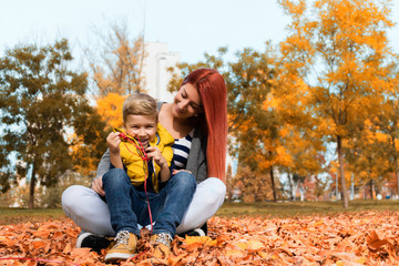 Happy mother and son during autumn day at the park.