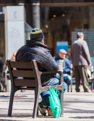 Men are sitting on chairs in the city center, Barcelona, Catalonia, Spain. With selective focus.