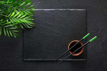 Foto op Plexiglas Eetstokjes en bamboekom op zwarte rotsleiplaat © nioloxs