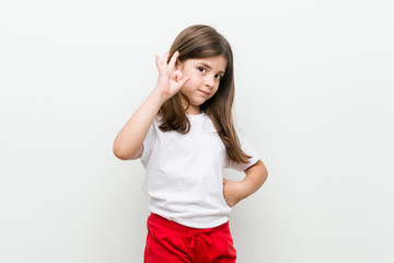 Little caucasian girl cheerful and confident showing ok gesture.