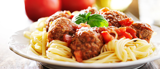 spaghetti and meatballs with basil garnish