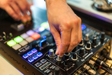 close-up photography of dj hands mixing music in a club, selective focus.