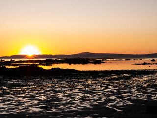Naklejka premium puesta de sol en el mar con barcos pesqueros al fondo