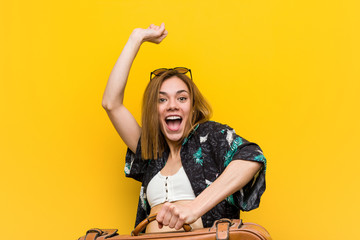 Young woman ready to go to vacation over yellow background