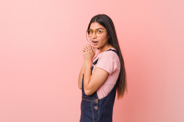Young pretty arab woman wearing a jeans dungaree scared and afraid.