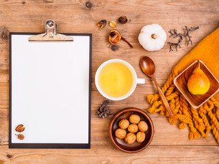 Eine Tasse Tee mit Birne, Walnüssen und unbeschriebenen Notizblock auf einem grauen Holztisch, rustikaler Stil, Flat lay