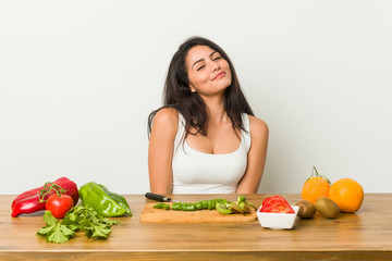 Young curvy woman preparing a healthy meal dreaming of achieving goals and purposes