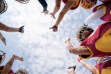 Photo from below of team of football players against blue sky