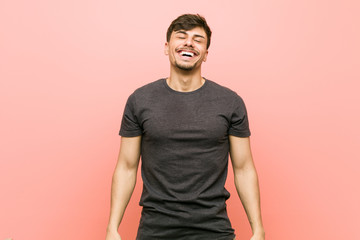Young hispanic casual man relaxed and happy laughing, neck stretched showing teeth.