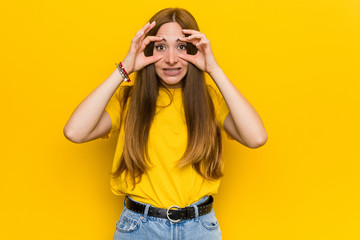 Young ginger redhead woman keeping eyes opened to find a success opportunity.