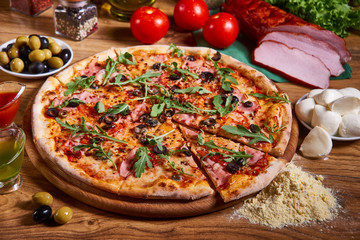 Pizza margarita with tomato sauce, fresh mozzarella, parmesan on the wooden rusty background. Hot big pepperoni pizza, tasty pizza composition
