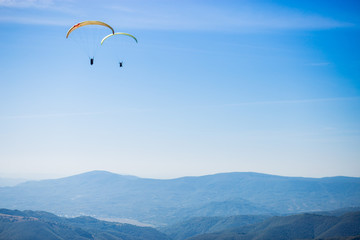 Paragliding group in air sport on top of a mountain. The whole world is in sight. Like a bird, out of gravity