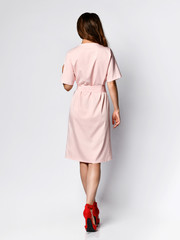 Full length portrait of happy beautiful woman in pink dress posing in studio isolated on white background