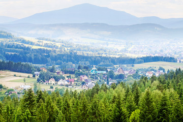 OBIDOWA, POLAND - JULY 03, 2019: Valley with small houses, covered with afternoon summer mist.