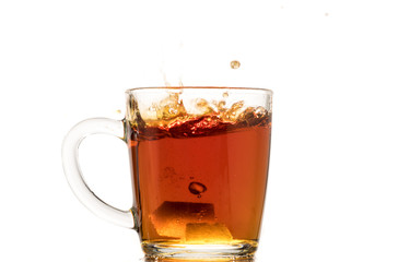 making black tea from a bag with sugar in motion on a white background