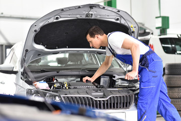 Fototapeta na wymiar car mechanic in a workshop repairing a vehicle