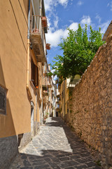 A narrow street between squares, monuments and colorful buildings in the town of Isernia, in Italy