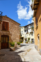 A narrow street between squares, monuments and colorful buildings in the town of Isernia, in Italy