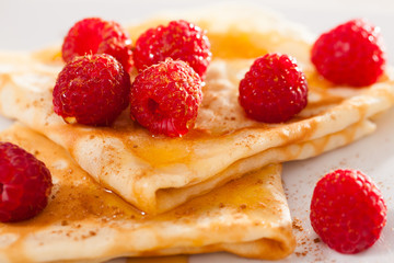 delicious  pancakes with fresh raspberries and honey