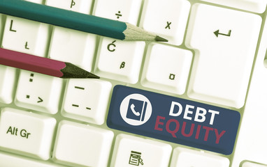 Writing note showing Debt Equity. Business concept for dividing companys total liabilities by its...
