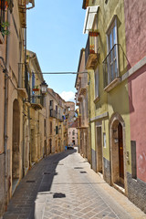 A narrow street between squares, monuments and colorful buildings in the town of Isernia, in Italy