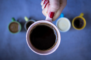 Coffee cup in woman hand, close up, top view.